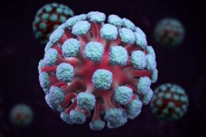 3D rendering of a coronavirus particle with blue-green spike proteins on a red core against a dark background
