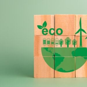 Wooden blocks form a green eco illustration with wind turbines, trees and a globe.