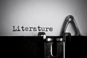 Close-up of a vintage typewriter typing the word 'Literature' on paper.