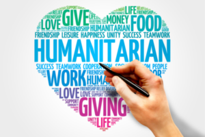 Heart-shaped word cloud about humanitarian aid with a hand drawing over words like give, giving, food, life, love, and work.