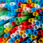 Colorful plastic drinking straws stacked together in a vibrant bundle.