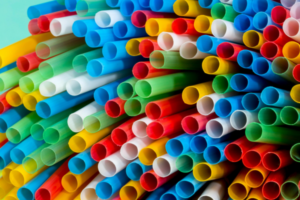Colorful plastic drinking straws stacked together in a vibrant bundle.