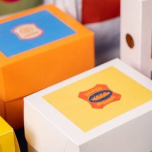 Colorful toy boxes with blue, yellow, and orange lids stacked together on a table.